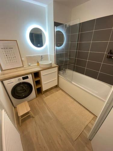 une salle de bain avec une machine à laver et un lavabo dans l'établissement Appartement - Visitez Paris, à Aubervilliers