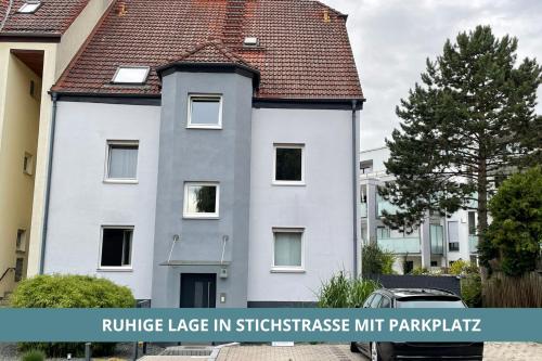 une maison blanche avec un toit marron dans l'établissement Semper Suite No2 - Ruhige 2 Zi FeWo 1-4 Pers mit Küche, Duschbad, Balkon und Parkplatz in Hofgartennähe, à Bayreuth