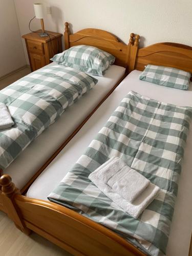 two beds with green and white sheets and towels at Landgasthaus zum Lammersdorferhof in Simmerath