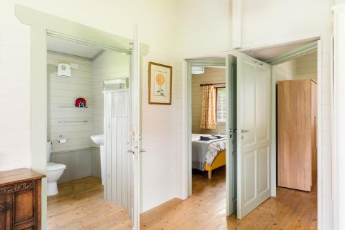 a bathroom with a toilet and a bed in a room at Iris Lodge, with cosy Log Burner 