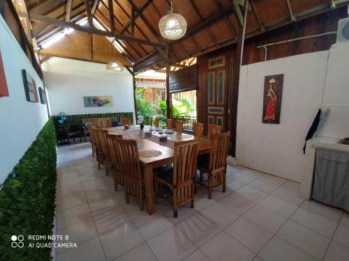 - une salle à manger avec une table et des chaises en bois dans l'établissement ASHVATTHA VILLA Canggu, à Canggu