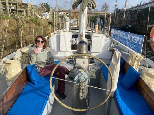 a woman sitting on the front of a boat at Stunning Yacht Sea Lion in Charlestown Harbour, Cornwall in Charlestown