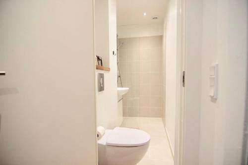 a white bathroom with a toilet and a shower at Refurbished 1-BR apartment in Charlottenlund - 180 in Charlottenlund
