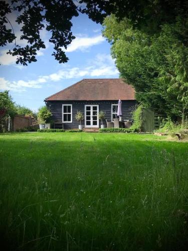 a small house in a field of green grass at Sissinghurst Stables in Cranbrook
