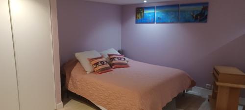 a bedroom with a bed with pillows on it at La pavillonnaise in Les Pavillons-sous-Bois