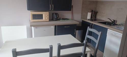une petite cuisine avec une table et un micro-ondes dans l'établissement La pavillonnaise, à Les Pavillons-sous-Bois