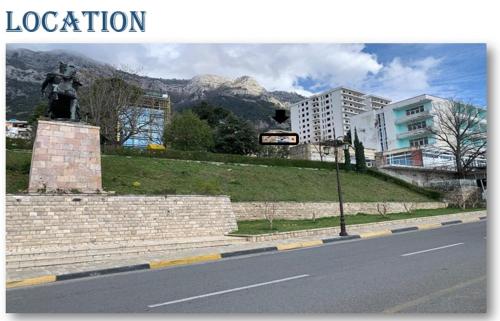 a statue on the side of a street with mountains in the background at Kruja Shared Apartment in Krujë