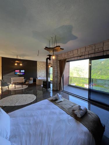 a bedroom with a large bed and a living room at Primland Suit in Çamlıhemşin