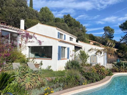 une maison blanche avec une piscine devant dans l'établissement Andromède, villa de charme avec vue et accès mer, au Pradet