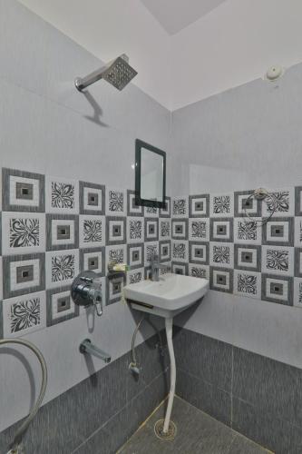 a bathroom with a sink and a mirror on the wall at Divine Glory Hotel in Lucknow