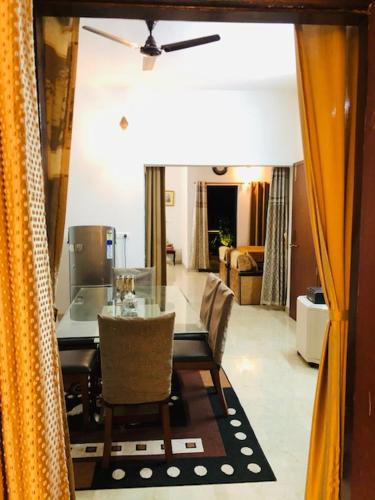 jadalnia ze stołem i krzesłami oraz salon w obiekcie Tattva Luxurious Apartment w mieście Waranasi