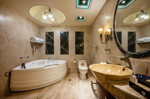 a bathroom with a large tub and a sink at Chokhi Dhani The Ethnic 5-Star Deluxe Resort in Jaipur