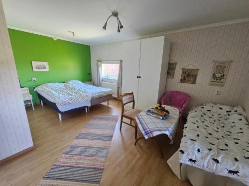 una camera con due letti e un tavolo con sedie di Bo på lantgård a Motala