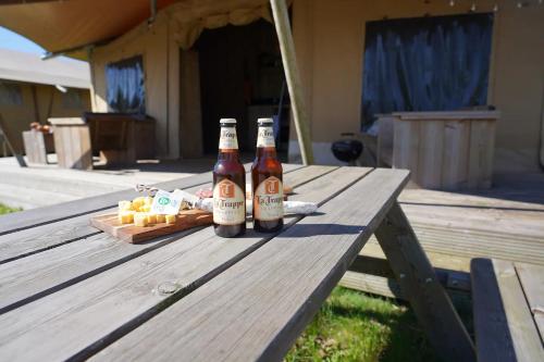 two bottles of beer sitting on a picnic table at Luxe en romantische overnachting 4 personen Grumpy in Behelp