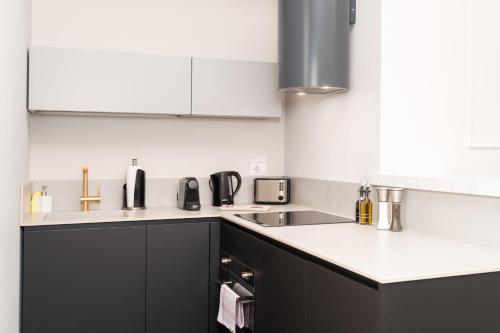 a kitchen with black cabinets and white counter tops at Limehome Lecce Palazzo BN in Lecce