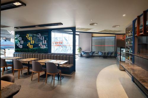 a dining room with tables and chairs in a restaurant at Lumen Bangkok Udomsuk Station in Bangkok