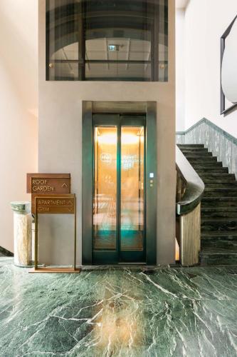 a lobby with a glass door and a staircase at Limehome Lecce Palazzo BN in Lecce
