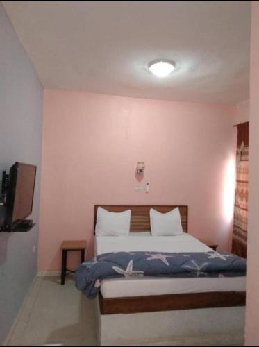 ein Schlafzimmer mit einem Bett in einem Zimmer in der Unterkunft Hotel Al Khayatt in Kaolack