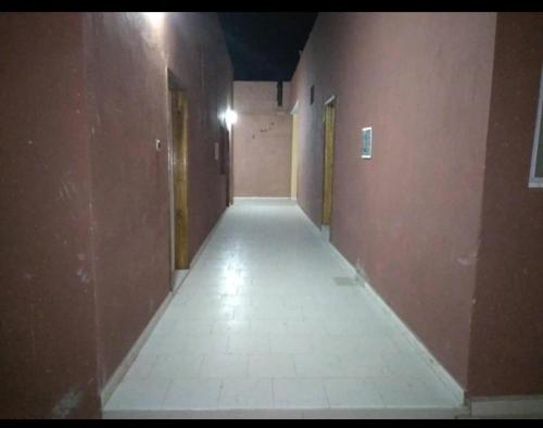 einen leeren Flur eines Gebäudes mit braunen Wänden in der Unterkunft Hotel Al Khayatt in Kaolack