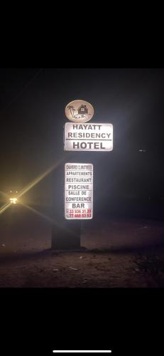 ein Schild für ein laxwegianwegianwegisches Hotel in der Nacht in der Unterkunft Hotel Al Khayatt in Kaolack
