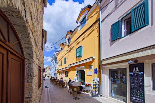 an alley with people sitting at tables on a street at Private room Niko in Skradin