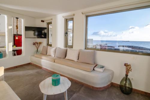 a living room with a couch and a large window at Casa di Mare Luxury Villas in Imerovigli