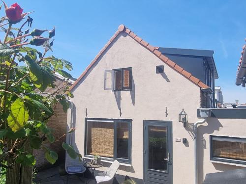 a white house with a window and a roof at cottage near the beach in the center.**** in Noordwijk aan Zee
