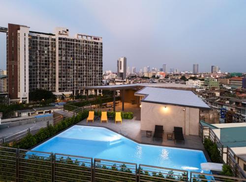 a large swimming pool on the roof of a building at Lumen Bangkok Udomsuk Station in Bangkok