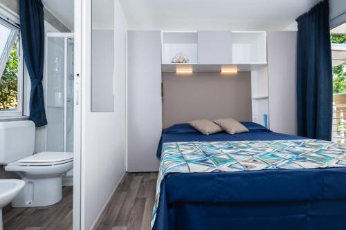 una piccola camera con letto e servizi igienici di Camping Village Baia Azzurra Club a Castiglione della Pescaia