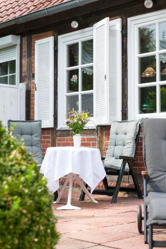 a table with a vase of flowers on a patio at Elbwiesenhaus mit schönen Garten in Lenzerwische