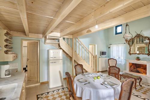 a dining room with a table and a staircase at Orelia Cretan Deluxe Apartments in Kamilari