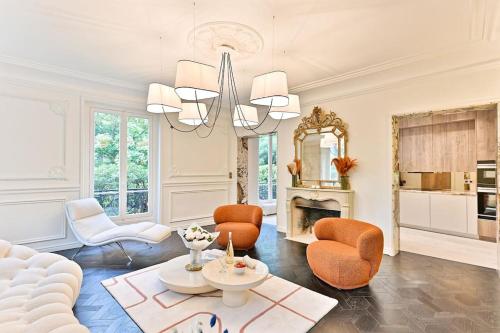 - un salon avec des chaises orange et une cheminée dans l'établissement Appartement d'architecte luxueux Neuilly-sur-seine, à Neuilly-sur-Seine