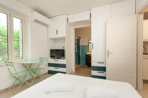 a white bedroom with a large bed and a table at San Teodoro - Civico 35 in San Teodoro