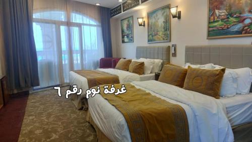a hotel room with three beds and a window at Resort altayar Villa altayar 1 Aqua Park with Sea View in Sidi Krir 