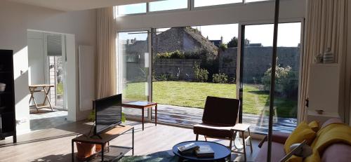 a living room with a large window and a couch at Maison neuve centre Barfleur in Barfleur