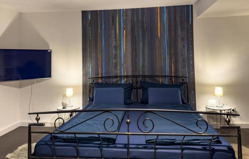 sypialnia z dużym łóżkiem z niebieską pościelą i niebieskimi poduszkami w obiekcie Apartelliment - smart übernachten in Köln w Kolonii