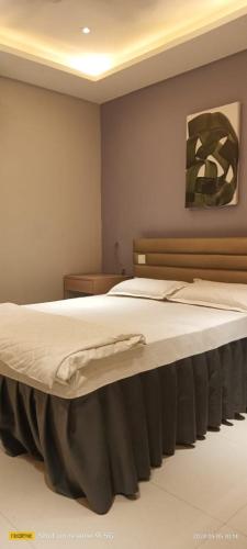 1 dormitorio con 1 cama grande con sábanas blancas en Manara Event, en Gwalior