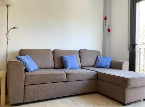 a couch with two blue pillows in a living room at Apartment Marina in Vilanova i la Geltrú
