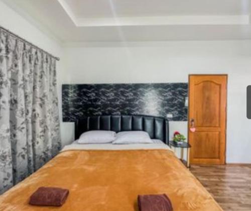 1 dormitorio con 1 cama grande y cabecero de madera en พลูวิลล่า villa pattay en Ban Rong Po