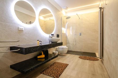 a bathroom with a sink and a toilet and a mirror at San Giorgio Loft in Bologna