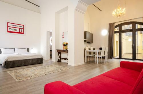 a living room with a bed and a red couch at San Giorgio Loft in Bologna