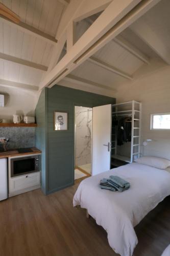 une chambre avec un grand lit et une cuisine dans l'établissement Rouleraventoux, Gîte sportif avec piscine, sauna, salle de sport, jardin, à Mormoiron