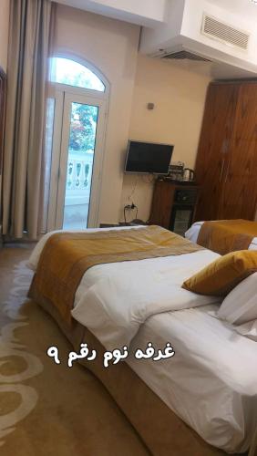 a bedroom with two beds and a large window at Resort altayar Villa altayar 1 Aqua Park with Sea View in Sidi Krir 