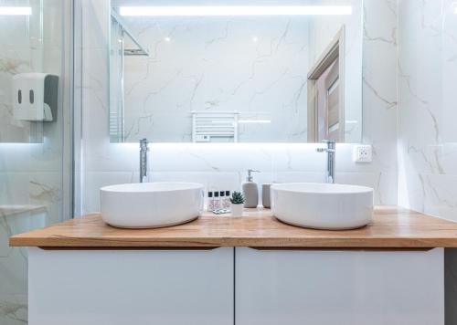 two white sinks on a wooden counter in a bathroom at Trois pièces cozy n14 in Nice