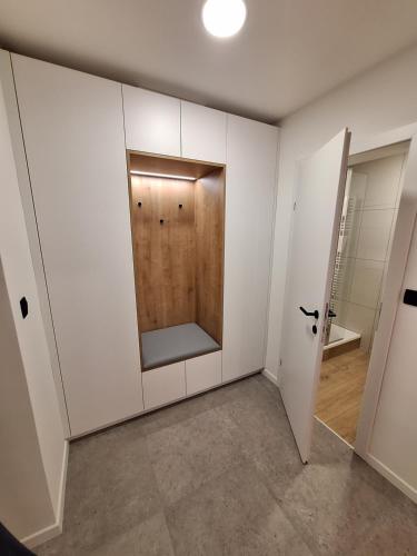 a room with white cabinets and a wooden door at Prenočišča Kralj in Komenda