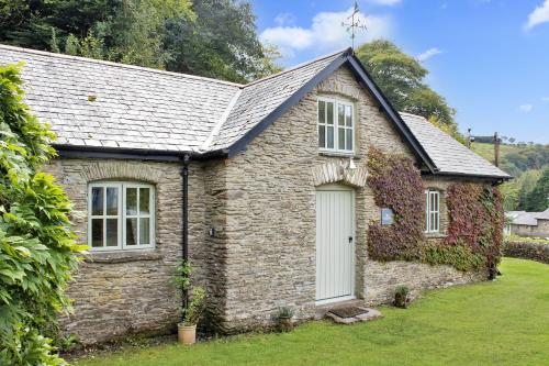 a small stone house with a white door at Birch Cleave Stable Simonsbath in Simonsbath