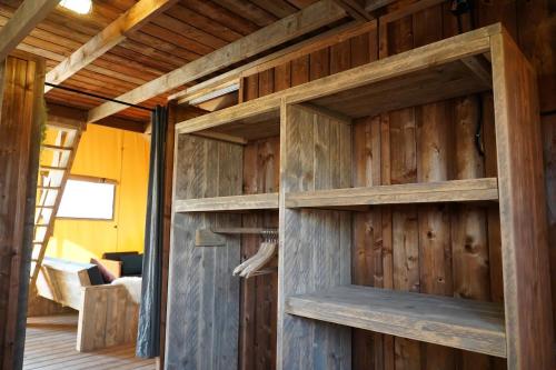 a wooden wall with wooden shelves in a room at Luxe en sfeervolle safaritent met eigen badkamer voor 6 personen Doc in Behelp