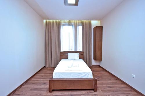 a white room with a bed and a window at Luxury White House In Yerevan in Yerevan