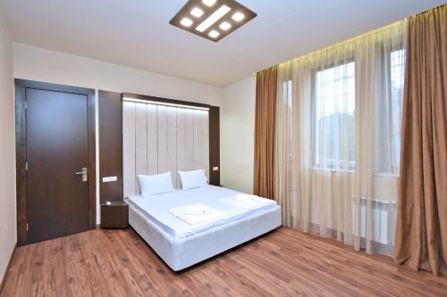 a bedroom with a white bed and a large window at Luxury White House In Yerevan in Yerevan