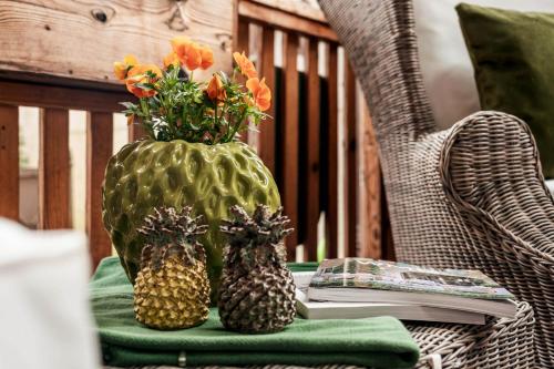 a green vase with two pineapples and flowers on a table at Mountainspirit in Mayrhofen